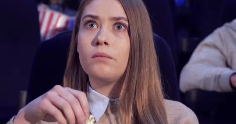 女生影院观看爆米花电影剪影视频素材 Girl Frowns at the Movie Theater