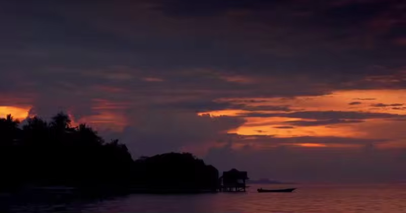 热带海岸晚霞风景背景视频素材 Colorful Sunset on a Tropical Coast and Motorboat