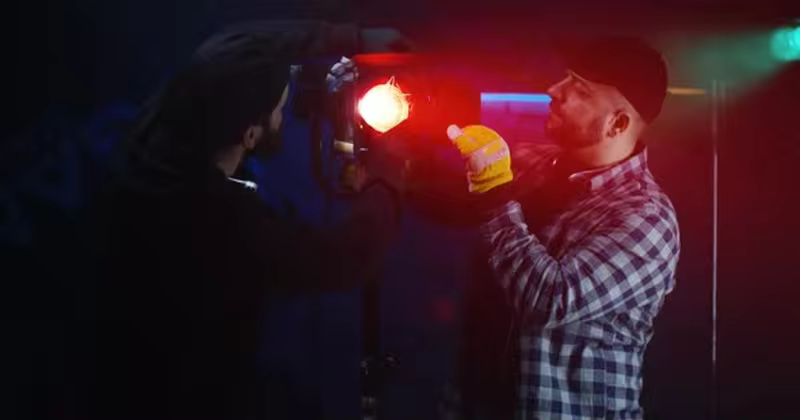 电影摄制组调试灯光场景影片素材 Film Crew Using a Fresnel Lamp